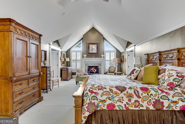 bedroom with lofted ceiling, a tiled fireplace, light colored carpet, ceiling fan, and a closet