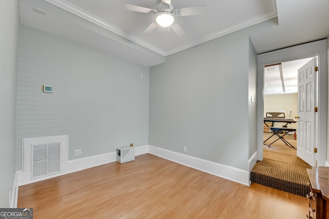 empty room with ornamental molding, ceiling fan, and light hardwood / wood-style flooring