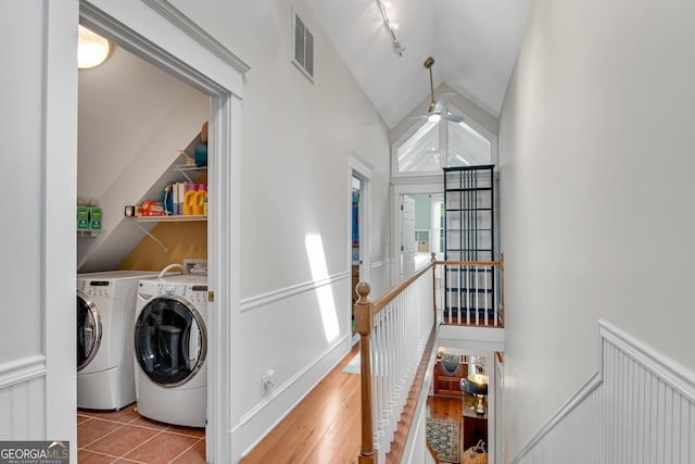 laundry area featuring light tile patterned floors, track lighting, and washing machine and clothes dryer