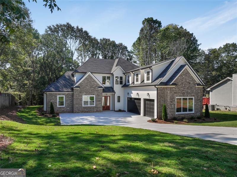 754 Moon Rd, Lawrenceville, GA 30046 - view of front facade with fence, concrete driveway, a front yard, an attached garage, and brick siding
