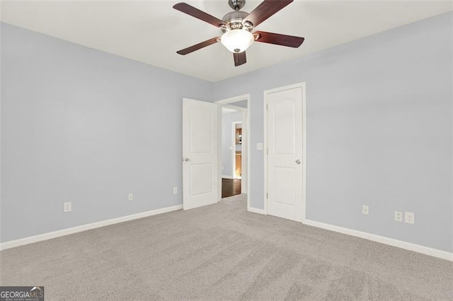 carpeted spare room featuring ceiling fan