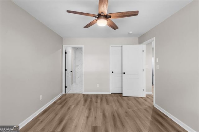 unfurnished bedroom with light wood-type flooring, ceiling fan, connected bathroom, and a closet