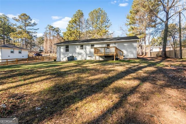 back of property featuring a deck and a yard