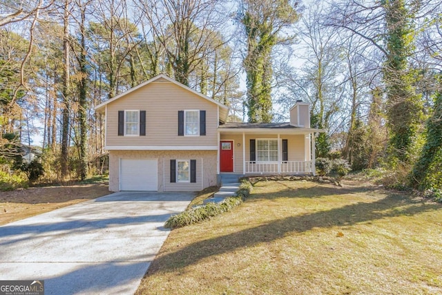 split level home with a porch, a garage, and a front lawn