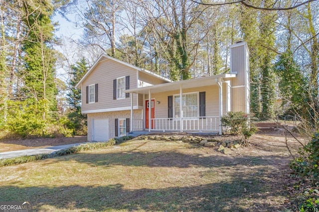 tri-level home featuring a garage, a front yard, and covered porch