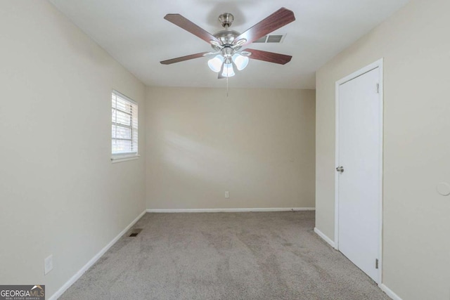 spare room with ceiling fan and light colored carpet