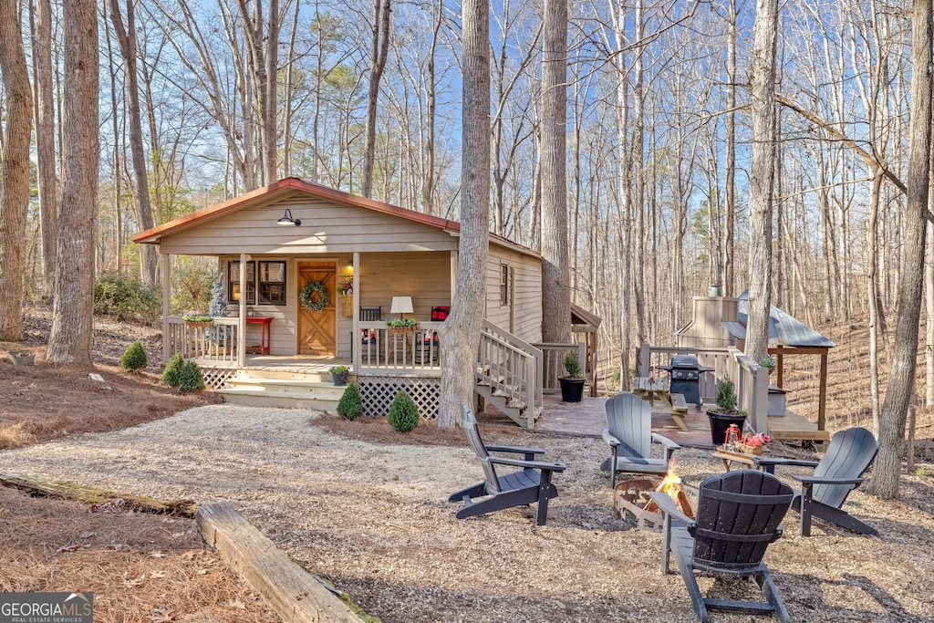 view of front facade featuring a fire pit and covered porch