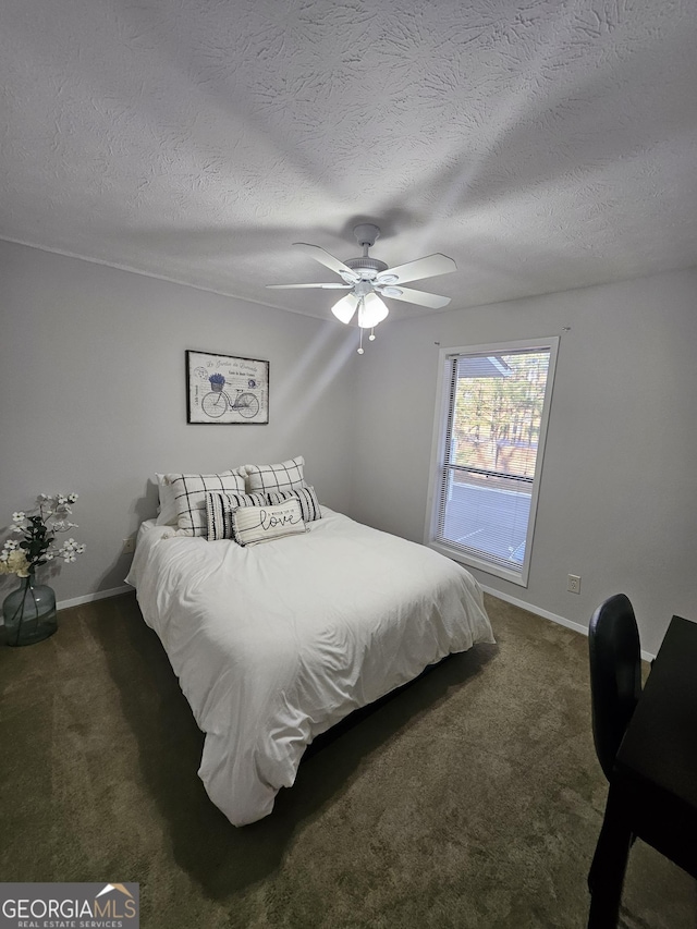 carpeted bedroom with a textured ceiling, a ceiling fan, and baseboards