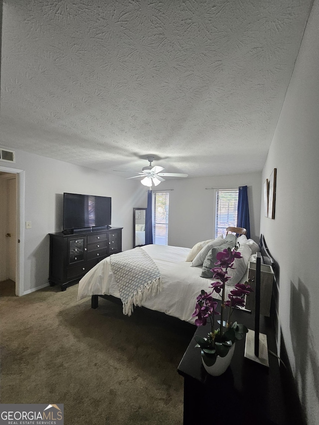 carpeted bedroom with ceiling fan, a textured ceiling, and visible vents