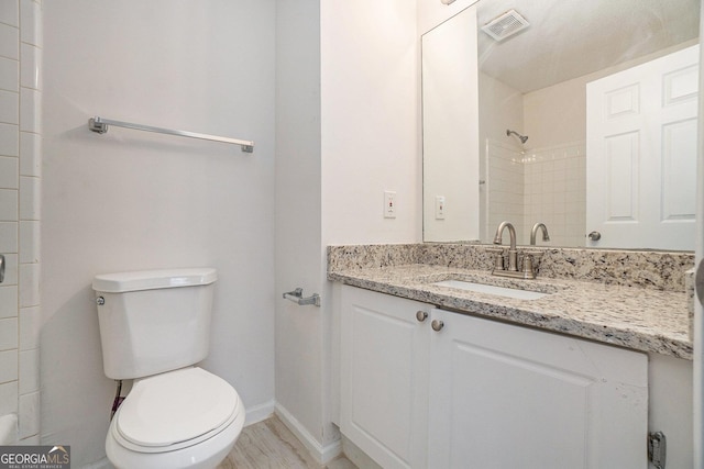 bathroom with walk in shower, vanity, and toilet