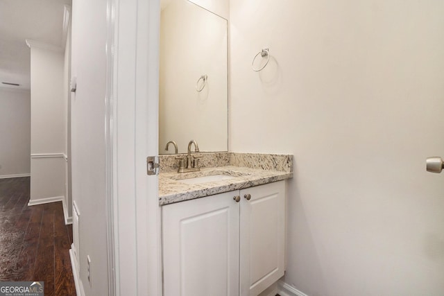 bathroom featuring vanity, hardwood / wood-style floors, and crown molding