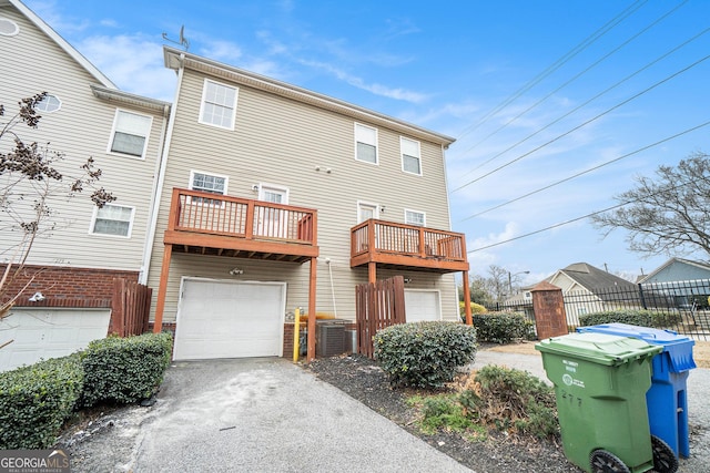 back of house with a balcony, a garage, and central air condition unit