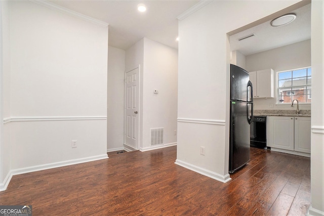 kitchen with white cabinetry, sink, black appliances, crown molding, and dark wood-type flooring