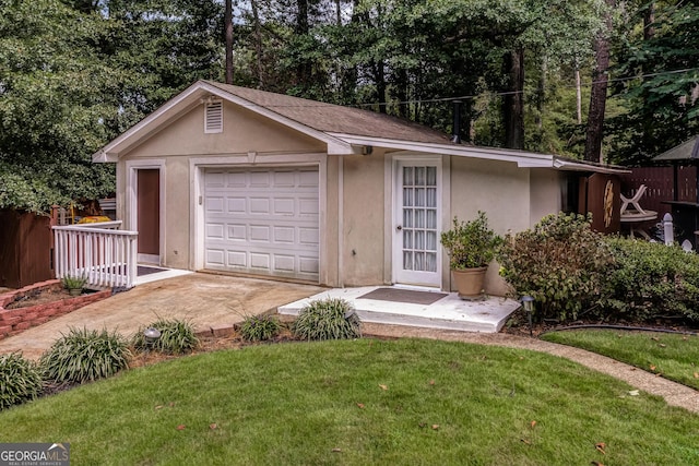 ranch-style home with a garage, an outdoor structure, and a front lawn