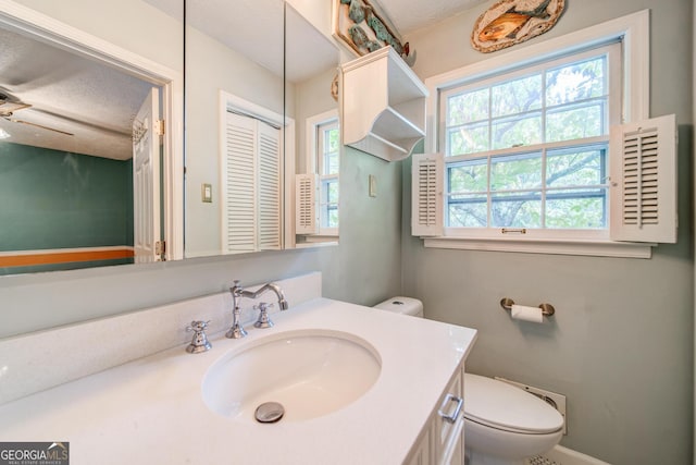 bathroom featuring vanity, a textured ceiling, and toilet