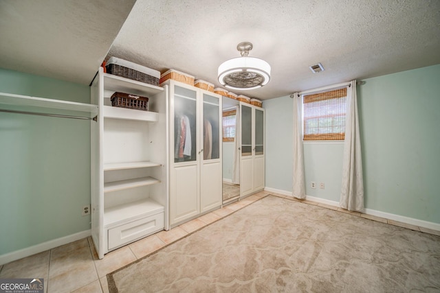 walk in closet with light tile patterned floors