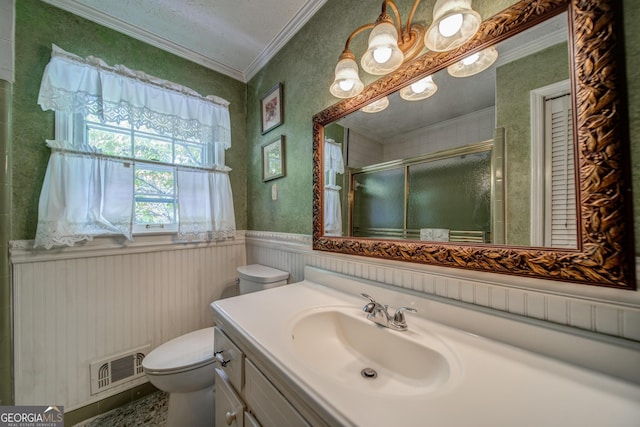 bathroom with crown molding, toilet, vanity, and walk in shower