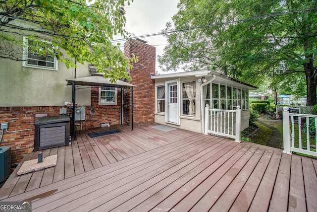 wooden deck featuring a gazebo and a sunroom