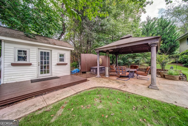 view of yard featuring a gazebo, an outdoor structure, a wooden deck, and a fire pit