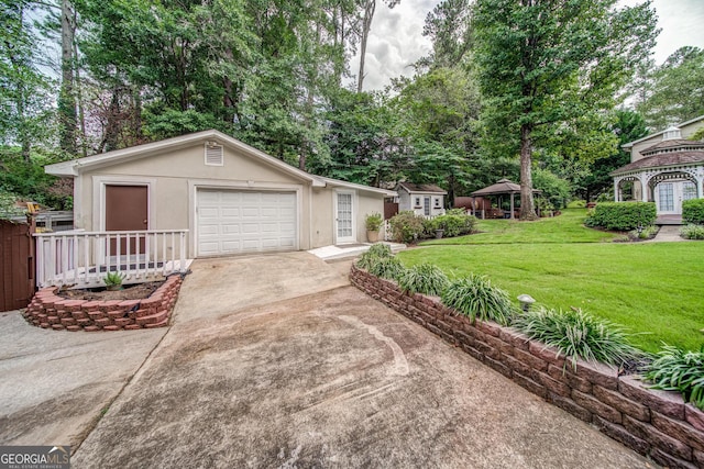 view of front of house with a garage, a gazebo, an outdoor structure, and a front lawn