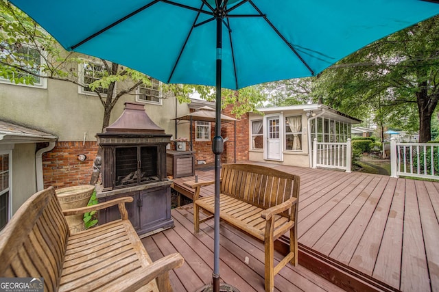 wooden terrace featuring an outdoor fireplace