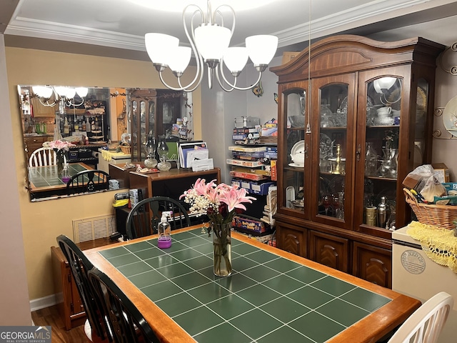 dining room featuring an inviting chandelier, hardwood / wood-style flooring, and ornamental molding