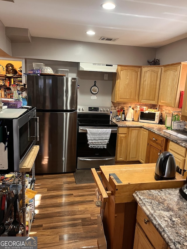 kitchen featuring dark hardwood / wood-style flooring, tasteful backsplash, and stainless steel appliances