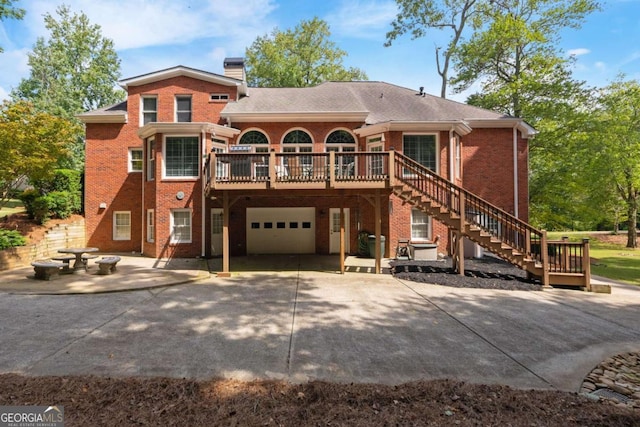 rear view of house featuring a garage and a deck