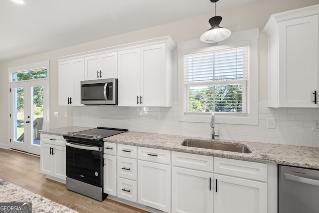 kitchen with white cabinetry, appliances with stainless steel finishes, sink, and pendant lighting