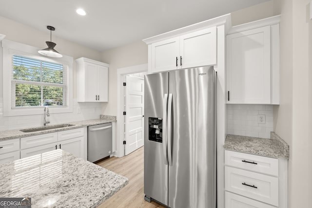 kitchen with pendant lighting, sink, tasteful backsplash, and appliances with stainless steel finishes