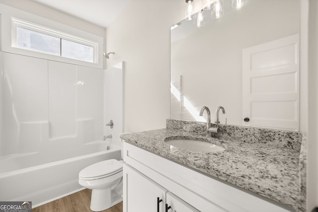 full bathroom with vanity, hardwood / wood-style flooring, bathtub / shower combination, and toilet