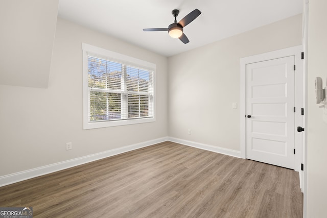 empty room with ceiling fan and light wood-type flooring