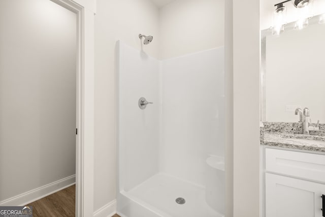 bathroom with vanity, wood-type flooring, and walk in shower