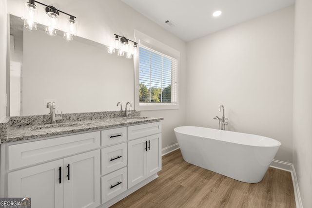 bathroom with vanity, a bathtub, and wood-type flooring