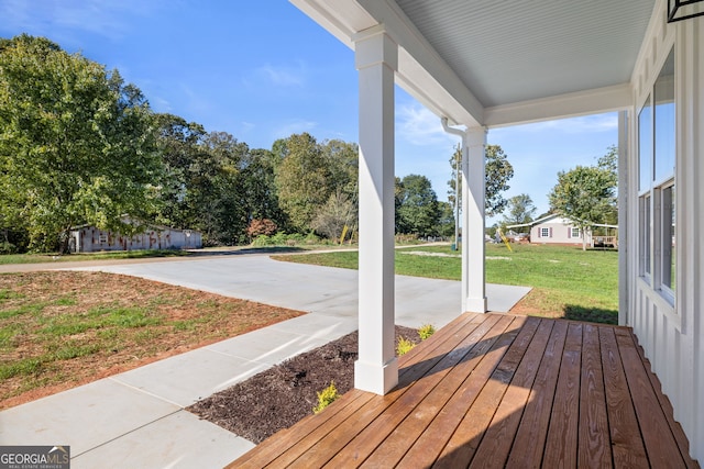 wooden terrace with a porch and a yard