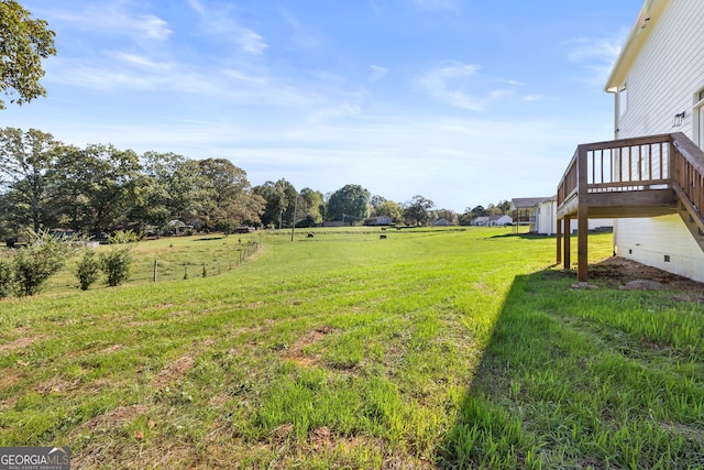 view of yard featuring a wooden deck and a rural view