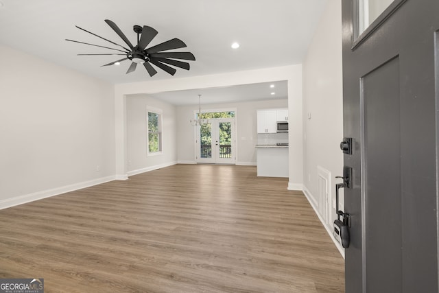 unfurnished living room with light hardwood / wood-style flooring and ceiling fan