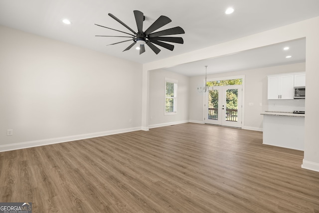 unfurnished living room featuring french doors, ceiling fan, and dark hardwood / wood-style floors