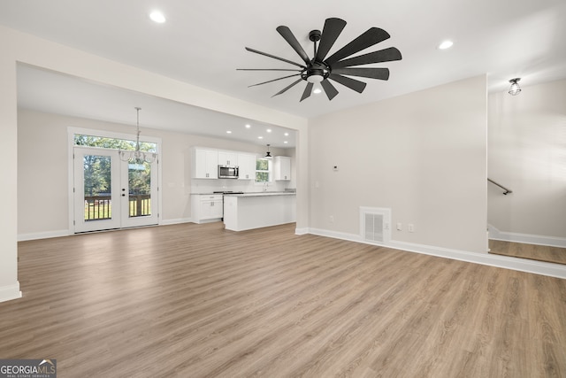 unfurnished living room with ceiling fan and light wood-type flooring