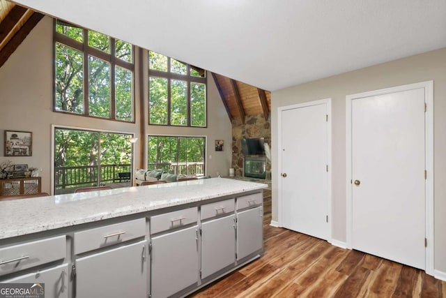 kitchen featuring gray cabinets, high vaulted ceiling, light stone countertops, dark wood-type flooring, and wooden ceiling