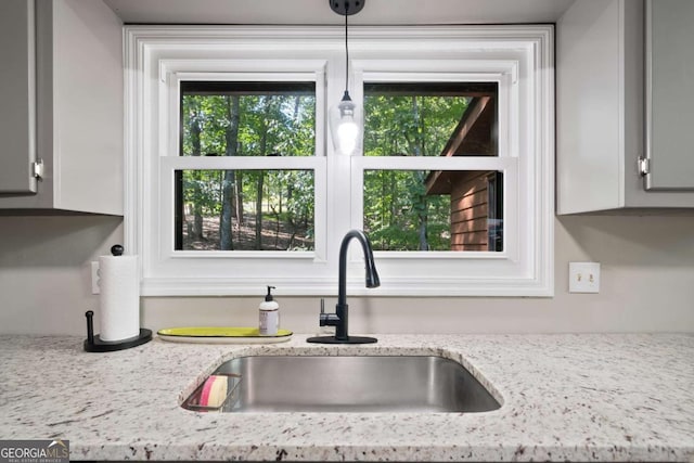 kitchen featuring light stone countertops and sink