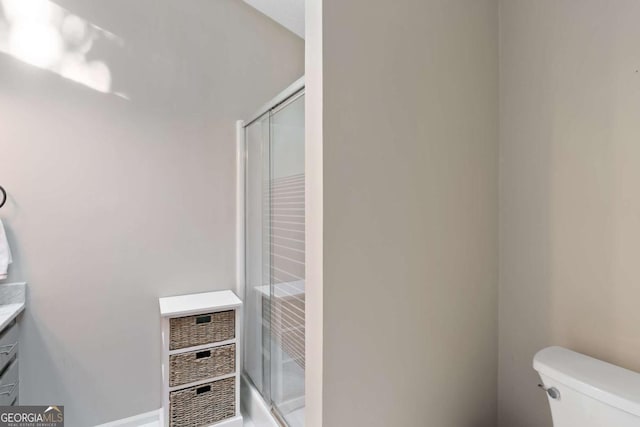 bathroom featuring walk in shower, vanity, and toilet