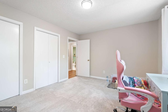 office space with light carpet and a textured ceiling