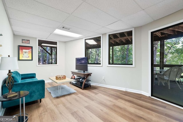 sitting room with a paneled ceiling, plenty of natural light, and light wood-type flooring