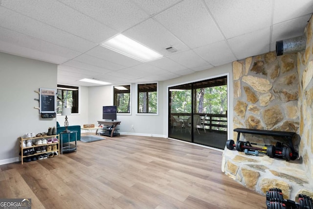 sitting room with wood-type flooring and a drop ceiling