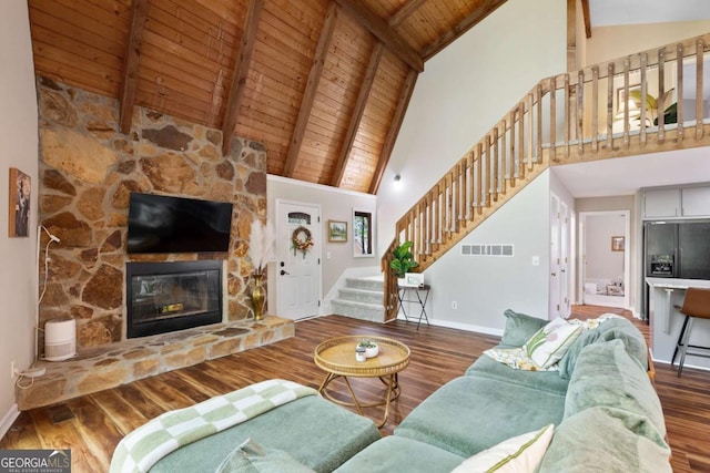 living room featuring high vaulted ceiling, a fireplace, beamed ceiling, dark wood-type flooring, and wooden ceiling