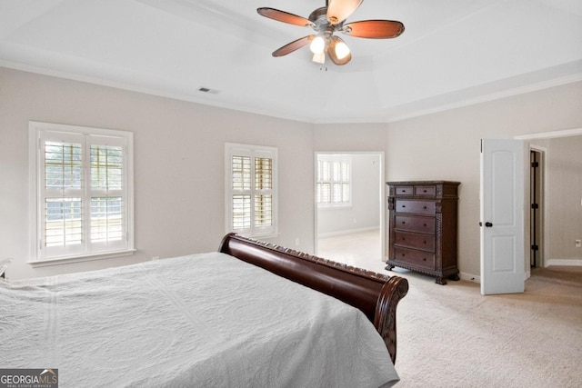 bedroom featuring crown molding, ceiling fan, a raised ceiling, and light carpet