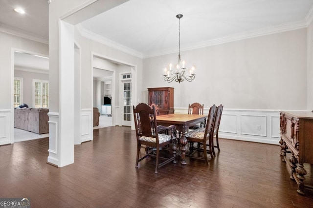 dining space featuring ornamental molding, dark hardwood / wood-style floors, decorative columns, and a notable chandelier