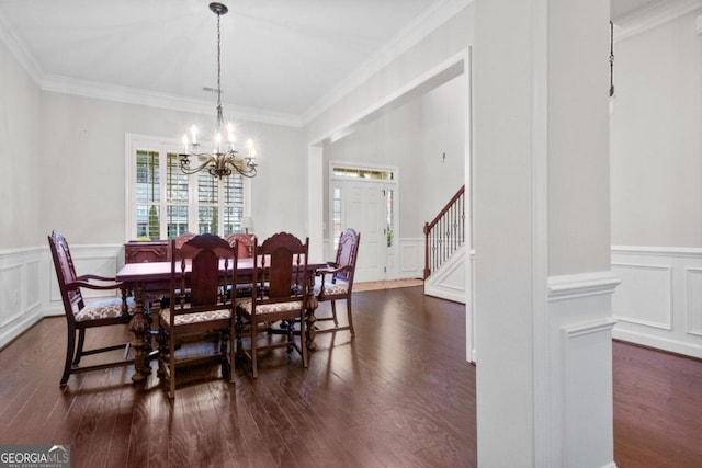 dining area with an inviting chandelier, ornamental molding, and dark hardwood / wood-style floors