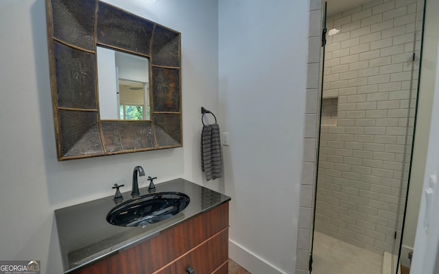 bathroom with vanity and a tile shower